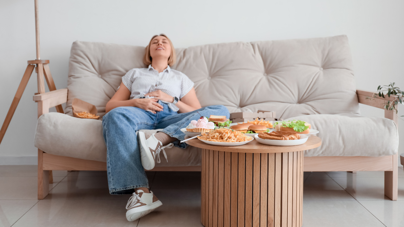 woman on couch holding her stomach